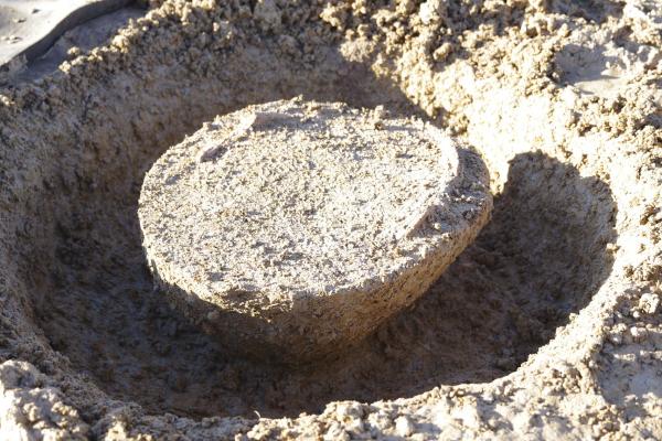 Sur leterrain, on aperçoit une motte de terre détourée par une grande rigole autour d'elle.