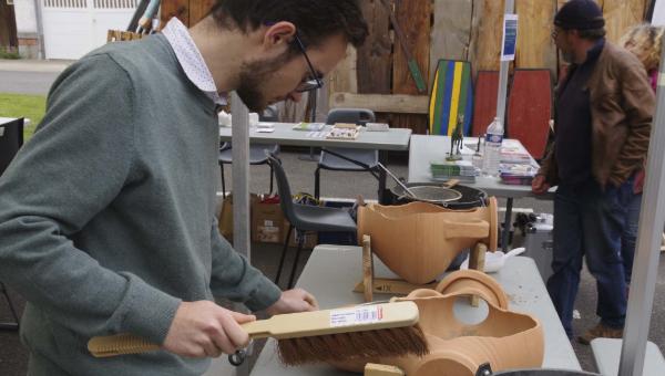 Un jeune homme est occupé à nettoyer l'atelier de fouille en amphore.