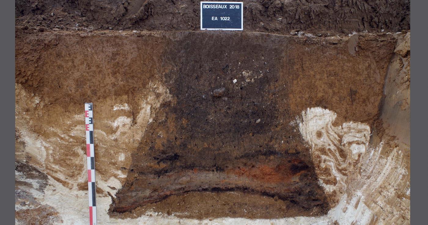 Un silo creusé dans le sol présente un comblement de sédiments très variés qui forment des couches distinctes superposées.