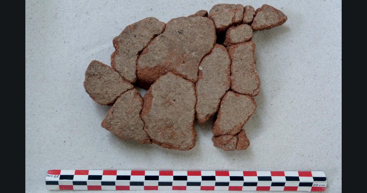 Fragments de terre cuite qui forment une plaque foyère reconstituée.