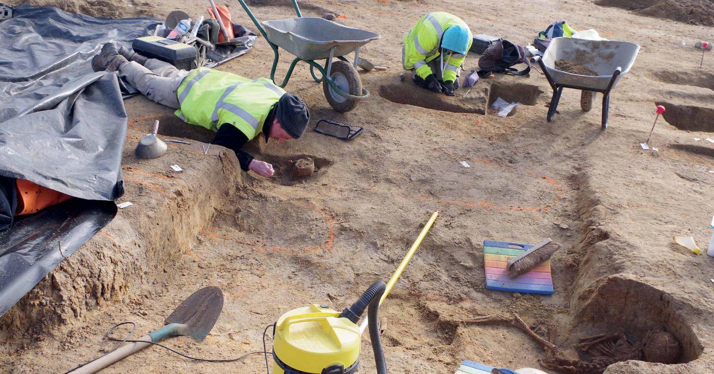 Des archéologues sont en train de fouiller des sépultures.