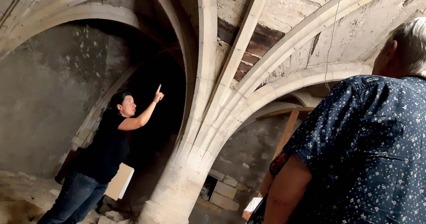 Une archéologue pointe du doigt les éléments architecturaux importants dans les caves du château de Gien.