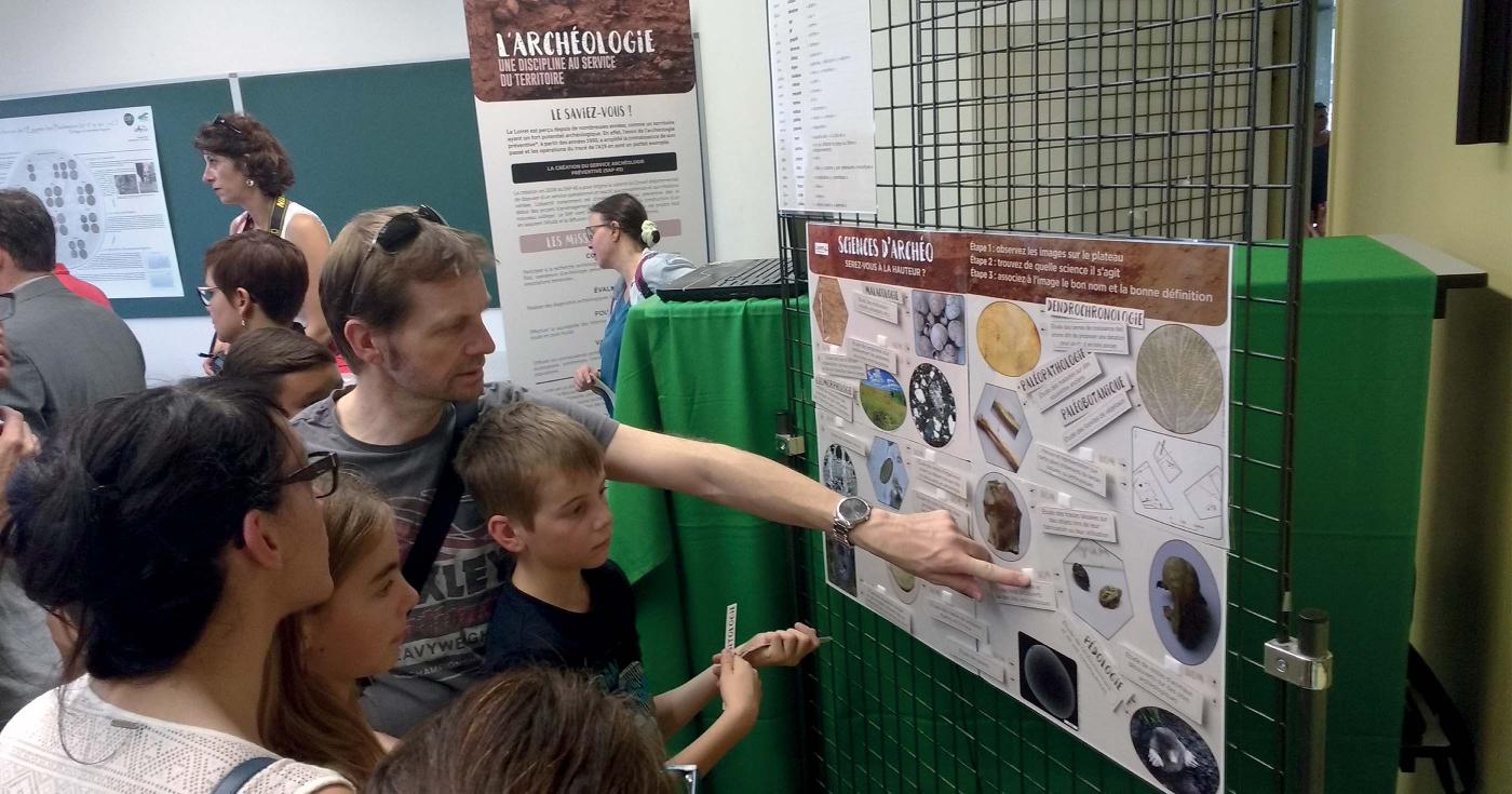 Le public cherche les réponses d'un jeu autour des sciences en archéologie.
