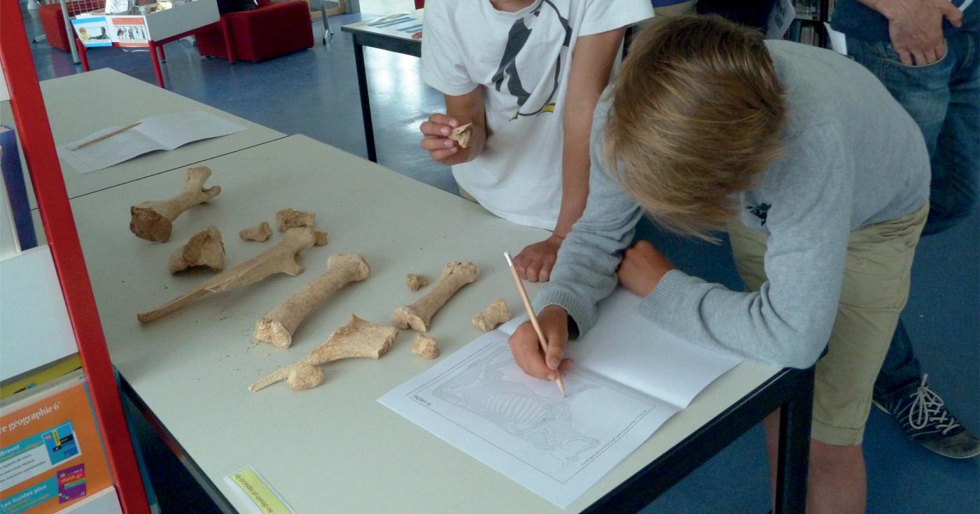 Des élèves de collège réalisent des ateliers pratiques sur des spécialités d'archéologie.