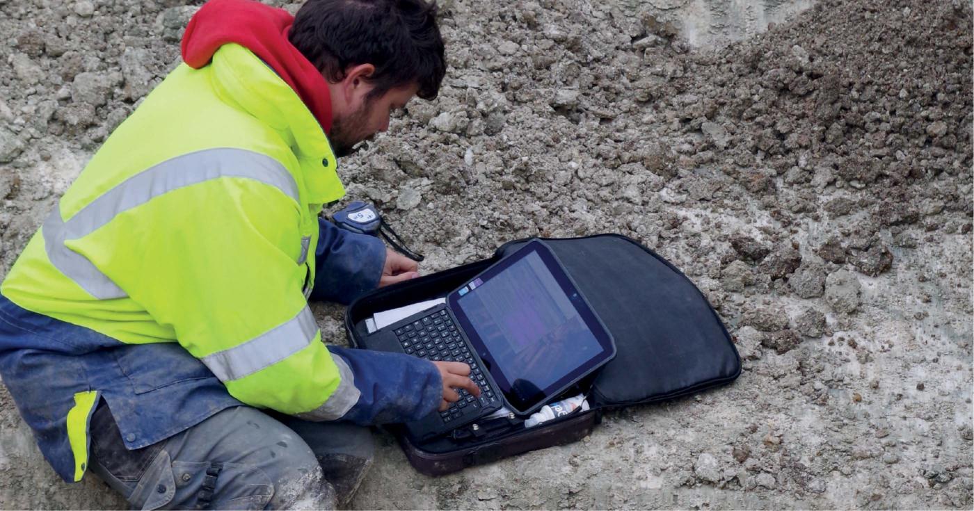 Un archéologue remplit les données archéologiques sur une tablette numérique.
