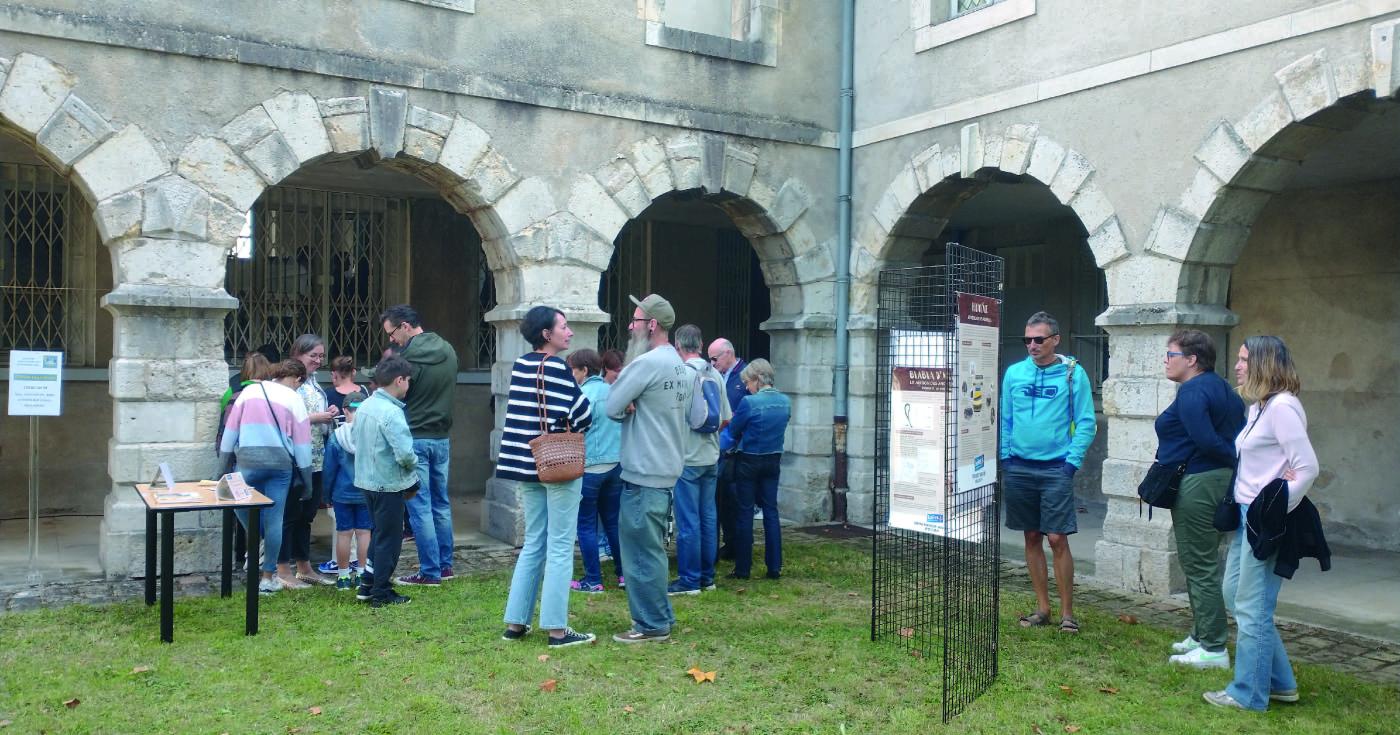 Vue d'une animation avec du public sous les arcades d'un cloître.