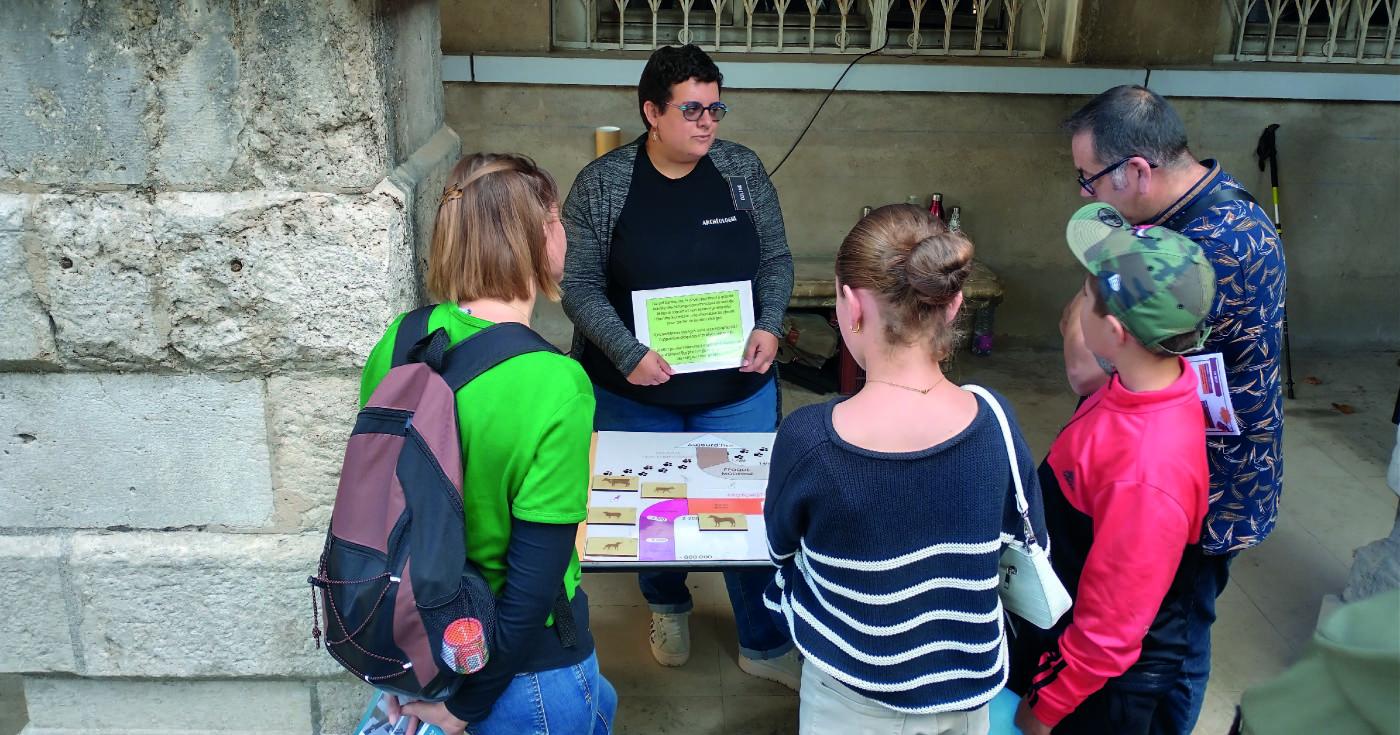 Photo d'une archéologue animant un jeu devant du public.